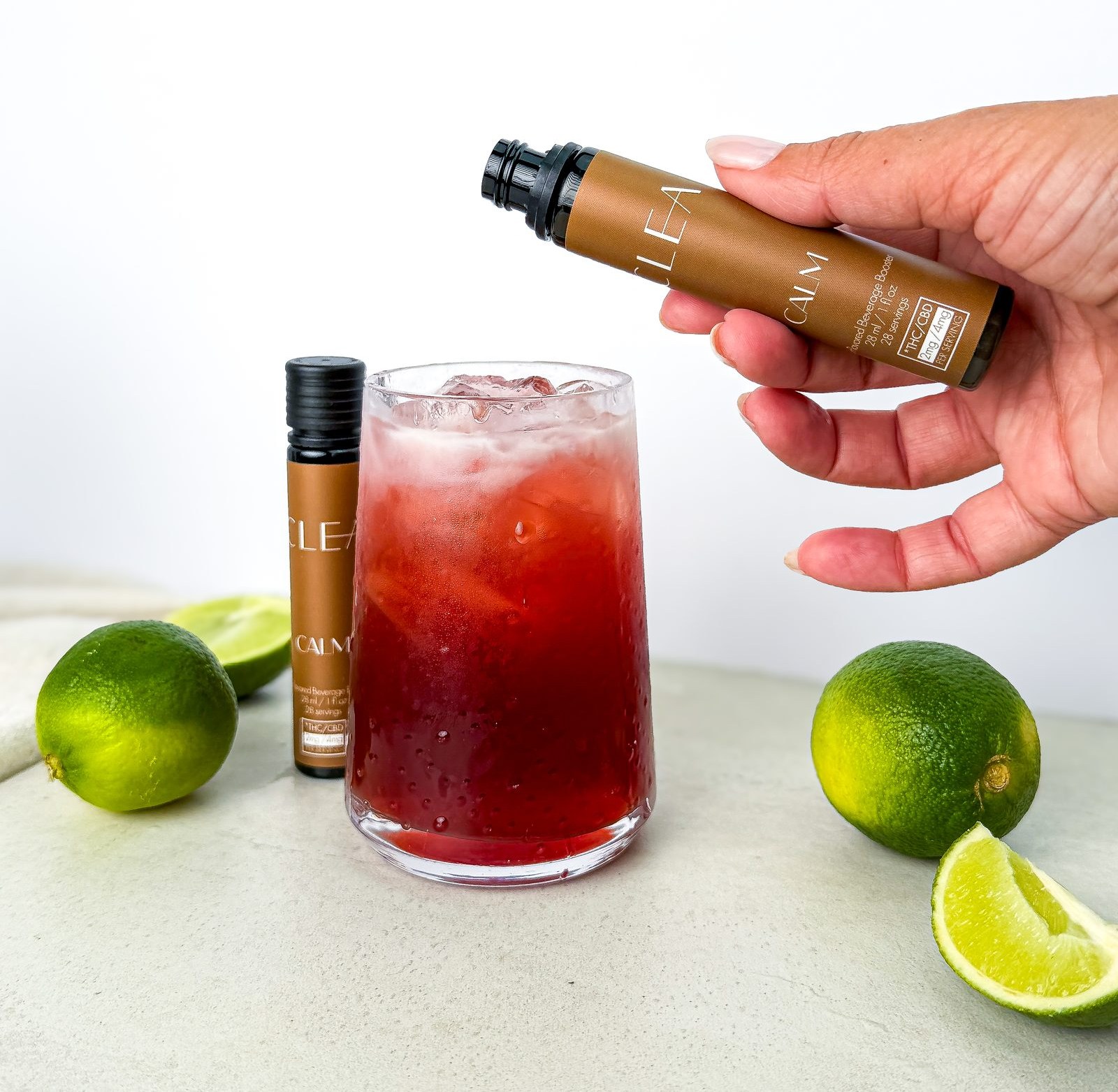CLEA CALM microdose beverage booster being added to a sparkling drink with fresh lime