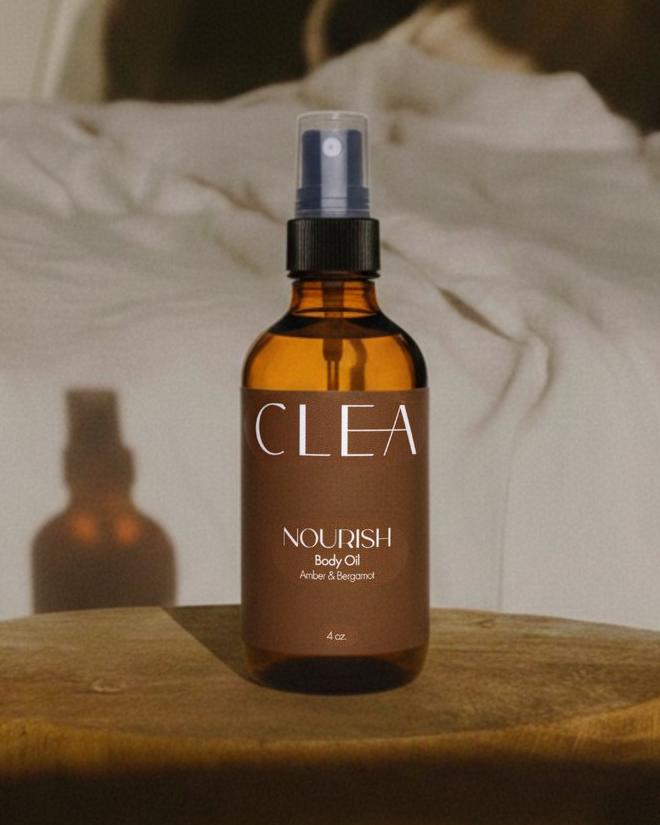 CLEA NOURISH body oil on a wooden stool in low evening light